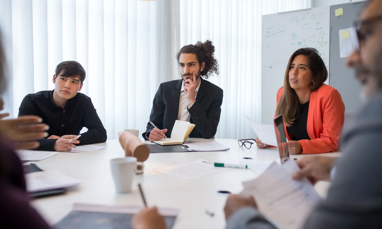 Meeting participants evaluating documents around a table